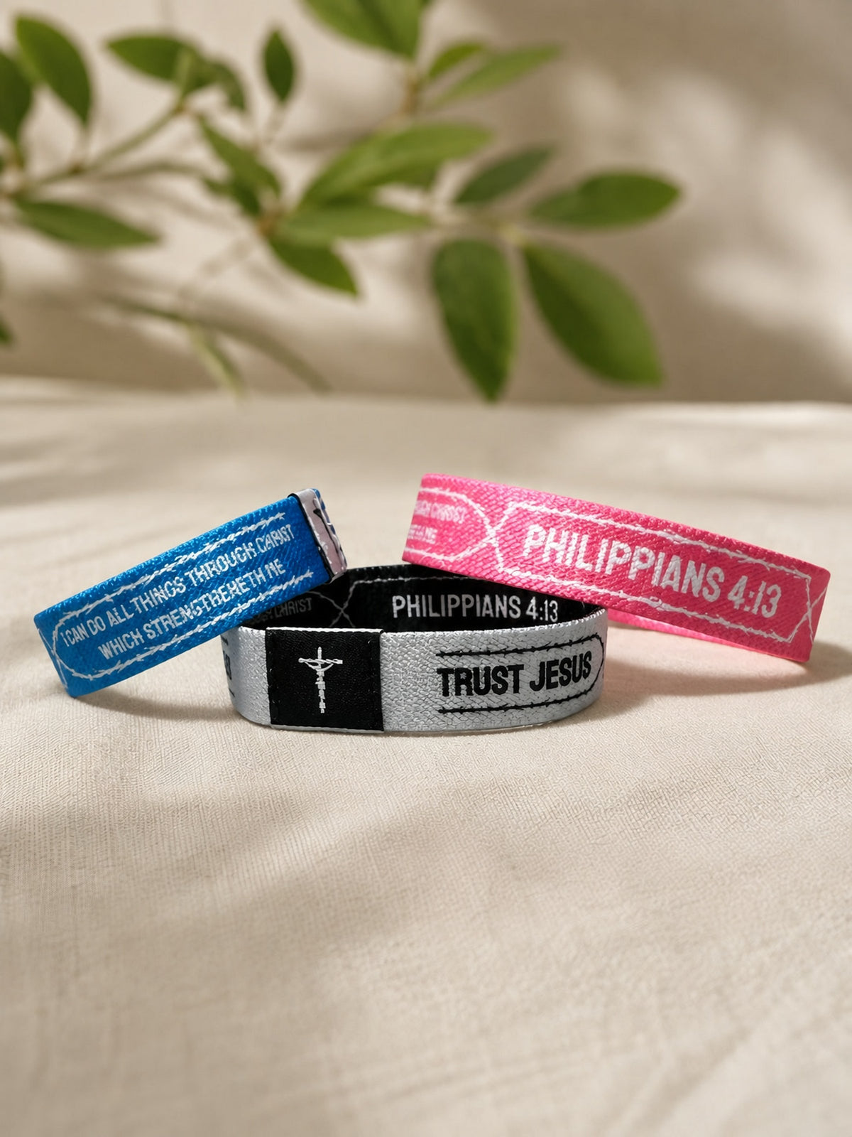 Trust Jesus NFC Bible verse wristbands in blue, white and pink on linen