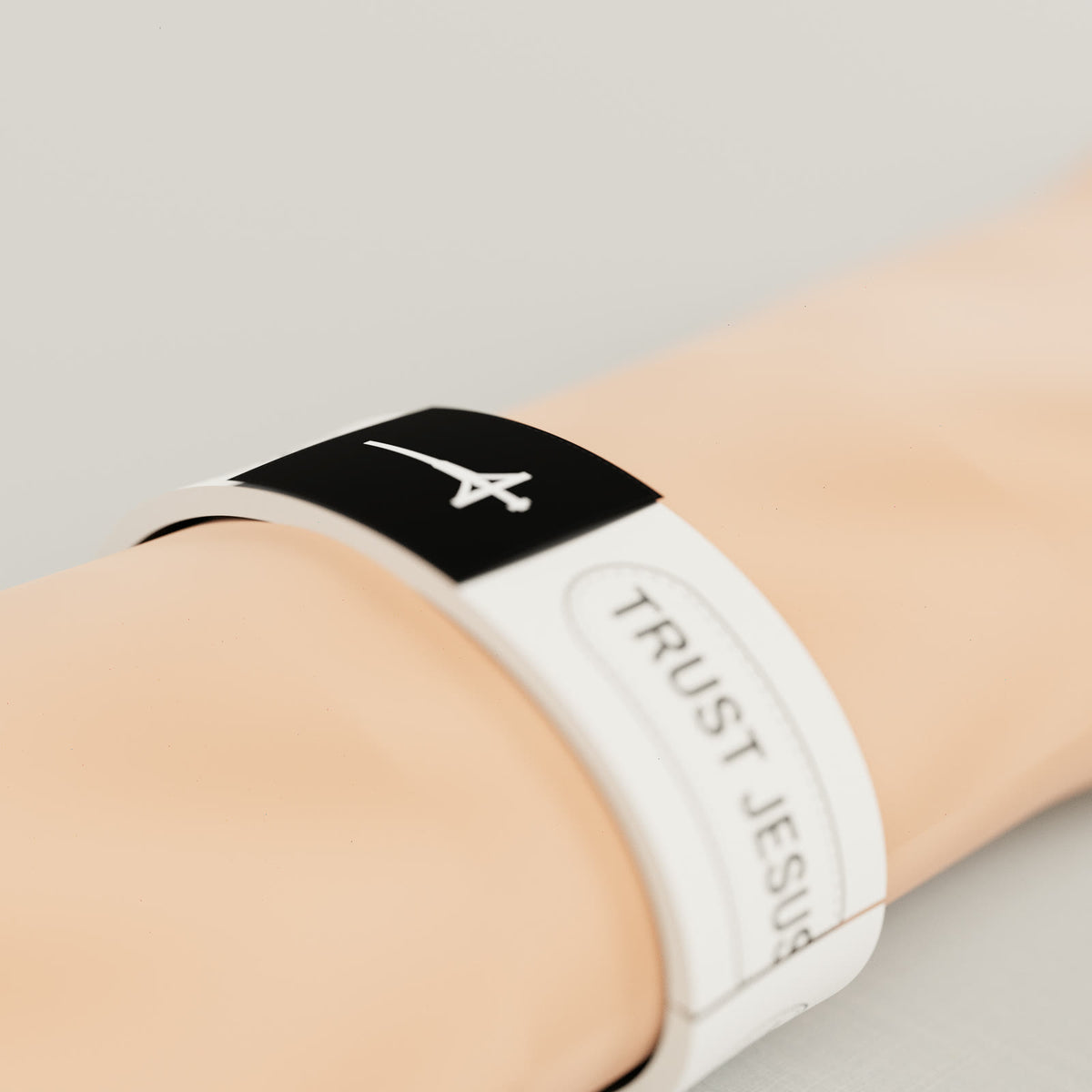 White Trust Jesus NFC wristband on a wrist, black cross patch on top where you tap your phone